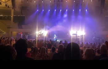 Singer Stephen Sanchez performing onstage under bright lights