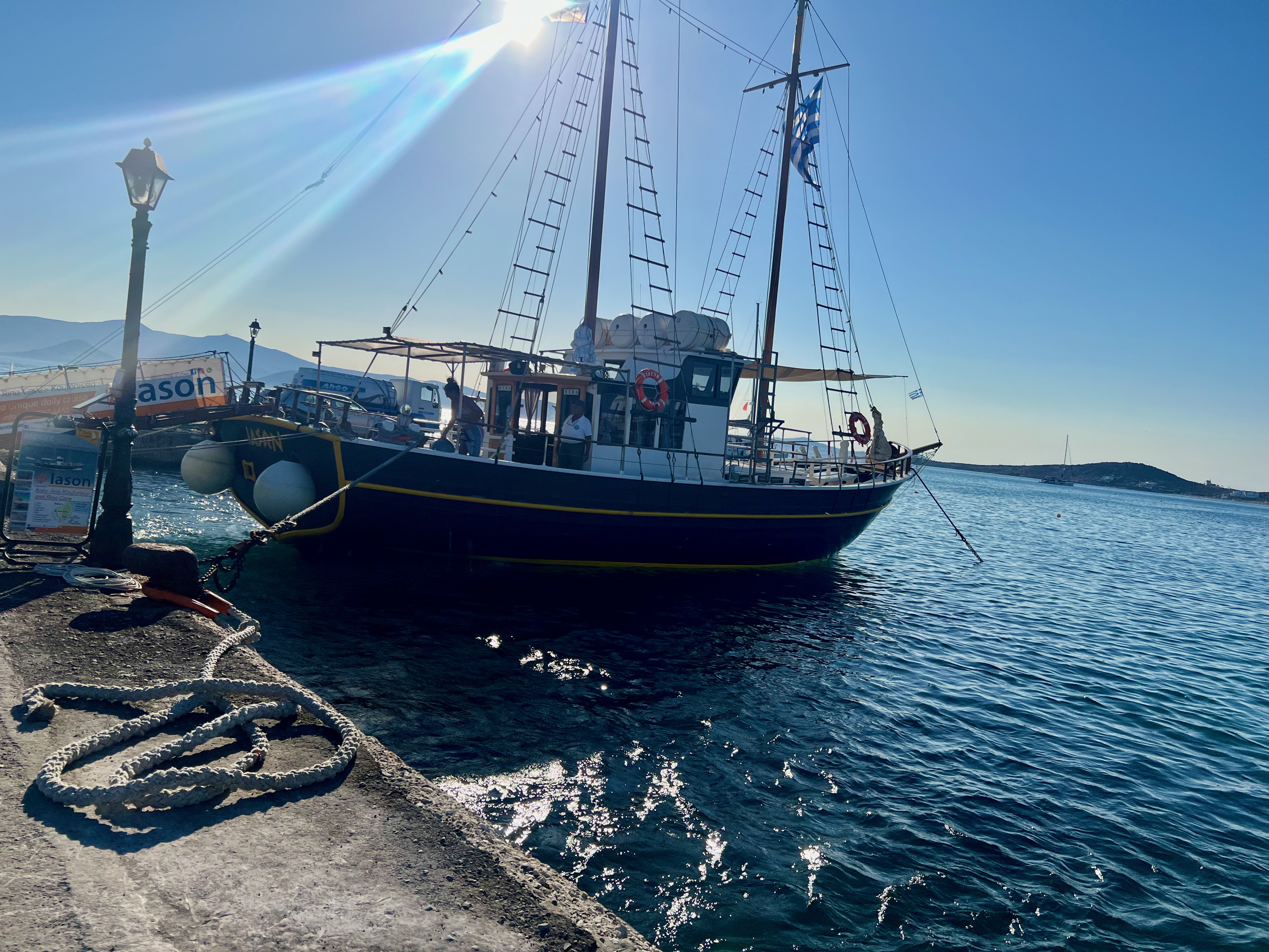 A mid sized boat flying a Greek flag docked in the Mediterranean Sea