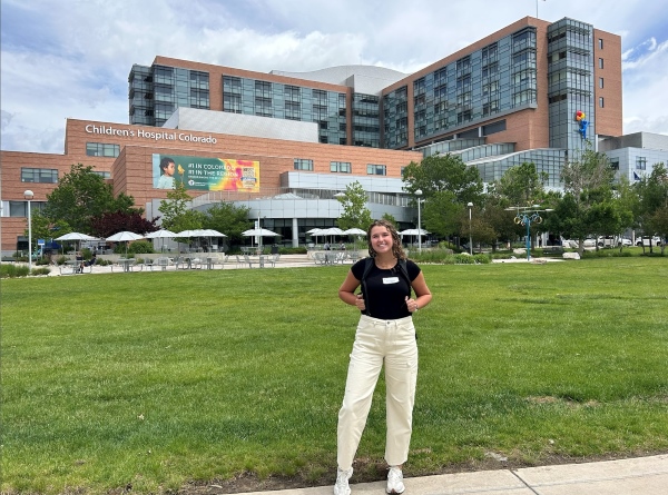 Ella standing in front of the Children's Hospital Colorado building