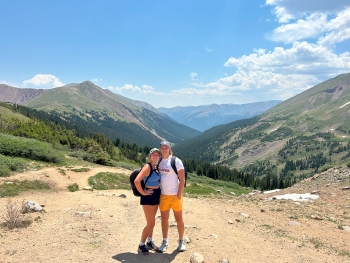 Ella and Jakob pose in a mountain landscape while on a hike.