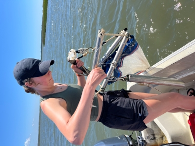 Emma putting the net into the water while doing zooplankton sampling.