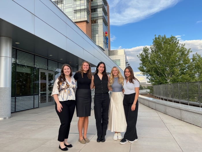 Group photo of Josalin, Ella, and the other Children's Hospital interns all dressed up outside a building