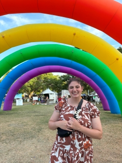 Kiana poses during Pride under a rainbow balloon