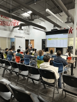 View from the back right corner of a lecture hall with a fairly full audience