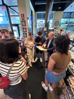 Dr. St. Louis in the middle of most of the interns in the lobby of what is apparently a pizza place