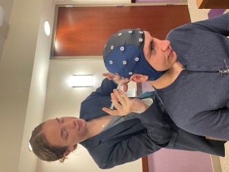 Laura adjusts Moodi's EEG cap to properly read is brainwaves