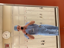 Selfie of Moodi in scrubs in a locker room