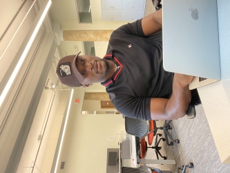 Photo of Michael-Sean working at his laptop in an office setting.