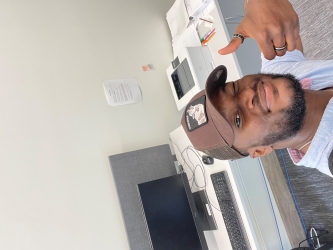 Michael-Sean flashes a thumbs up in this selfie at his office desk