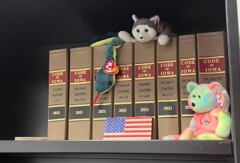 View of a book shelf with several Code of Iowa books amidst some stuffed Beanie Babies