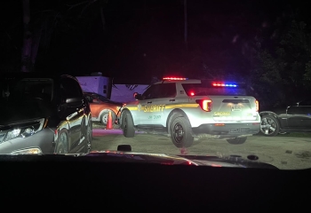 Photo of a Linn County Sheriffs Office cruiser at night from the headlights of a car behind it