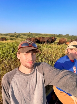 Selfie of Sam and a coworker with bison