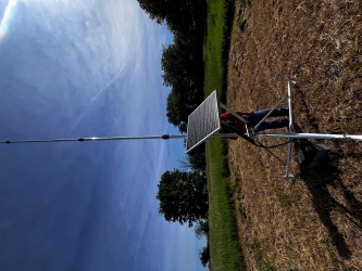 View of a virtual fence radio tower used to rein in cattle herds. It looks like a miniature solar panel with a tall antenna