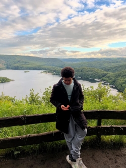 View of Saad leisurely posing with a wide expanse of lake in the background