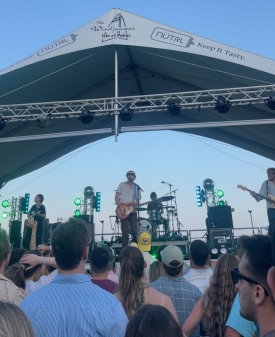 View of musicians on a concert stage from the audience, standing a hundred feet back or so