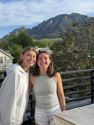 Photo of Alyza (right) with her friend Ava (left) posing with mountains in the background