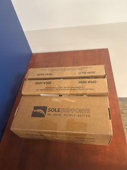 Group of sealed carboard shoeboxes containing completed foot castings