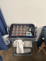 Various sizes of cups face down in a set along with what appears to be a timer and sets of hand towels