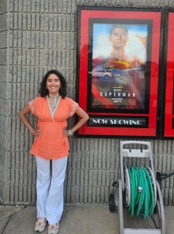 Claudia posing with the new Superman movie poster outside a movie theater