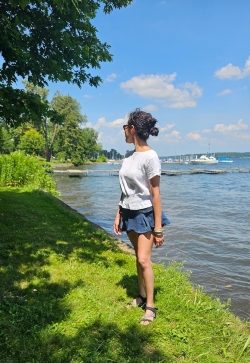 Claudia posing on a grassy bank at lakeside