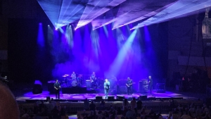 View from audience of a blue-lit stage where the band Counting Crows is performing