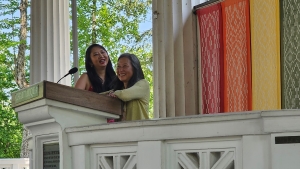 Two Asian women speak at a lectern