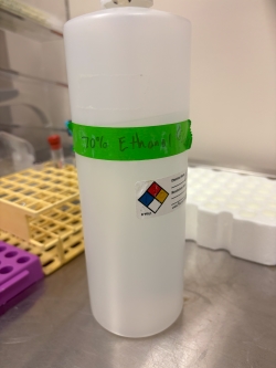 Plastic bottle with a green label that says 70% ethanol