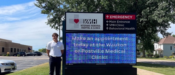 Charlie poses in front of the Veterans Memorial Hospital sign