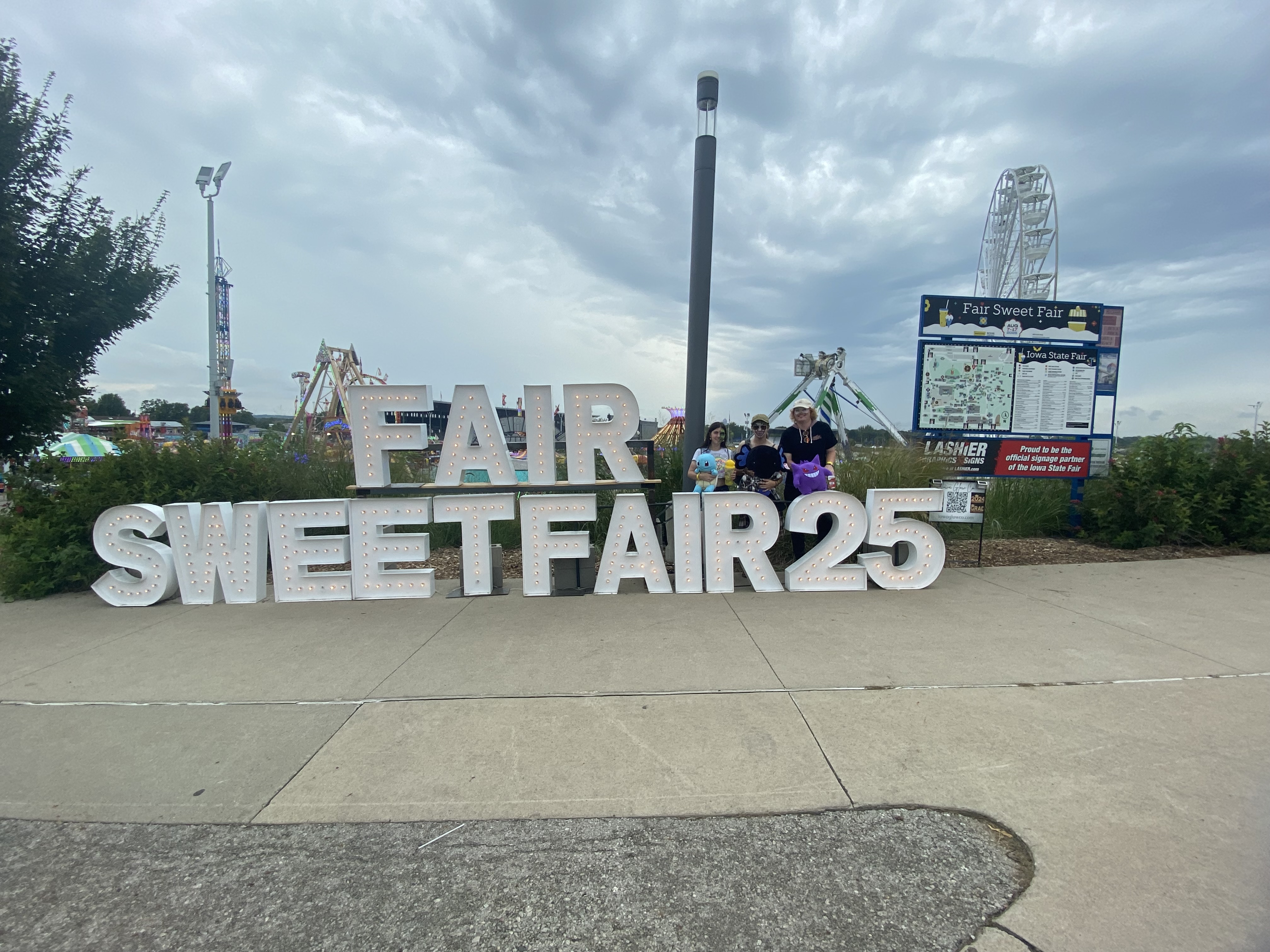 Picture of Celina and friends in front of state fair sign.