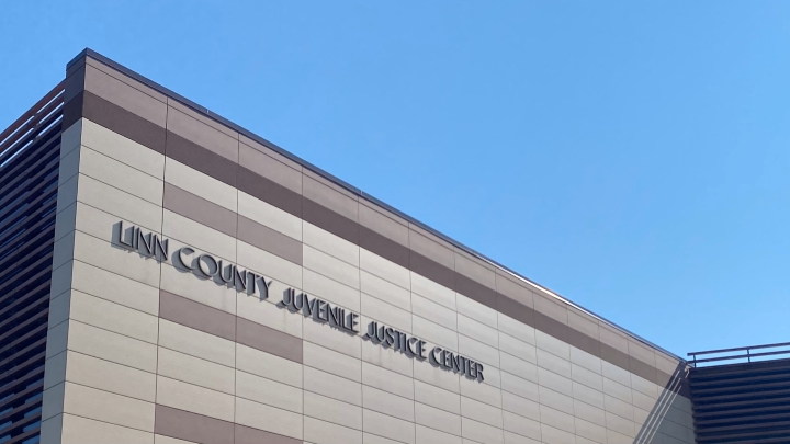 View looking up at a sign on a concrete building that says Linn County Juvenile Justice Center