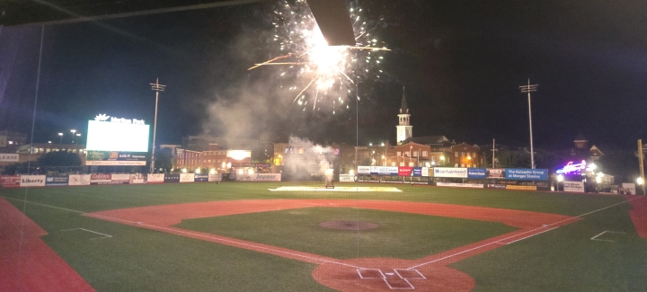 Nighttime fireworks over a baseball field