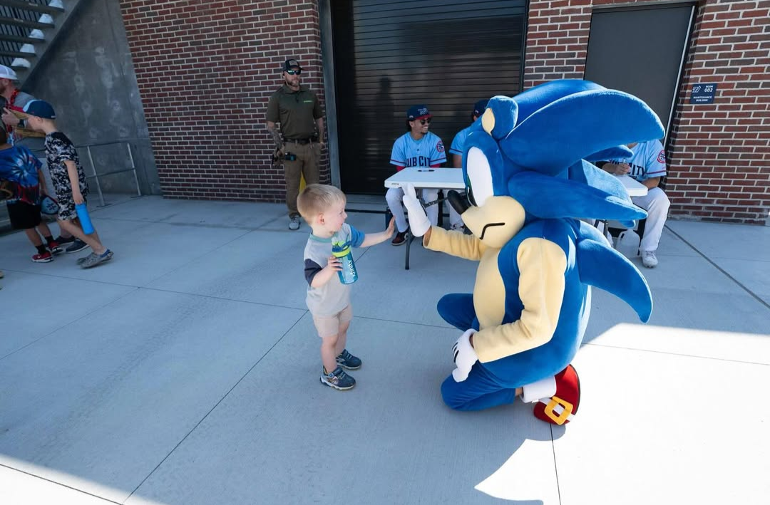 Evan as Sonic high-fiving a child.