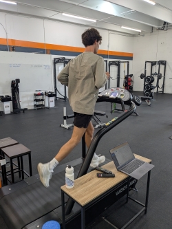 View of a young man from his right side as he runs on a treadmill for a Runeasi test