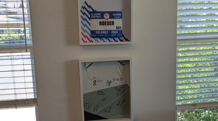 Close up of a framed runner's singlet. The last name Roeser is listed on the running bib that is also inside the frame