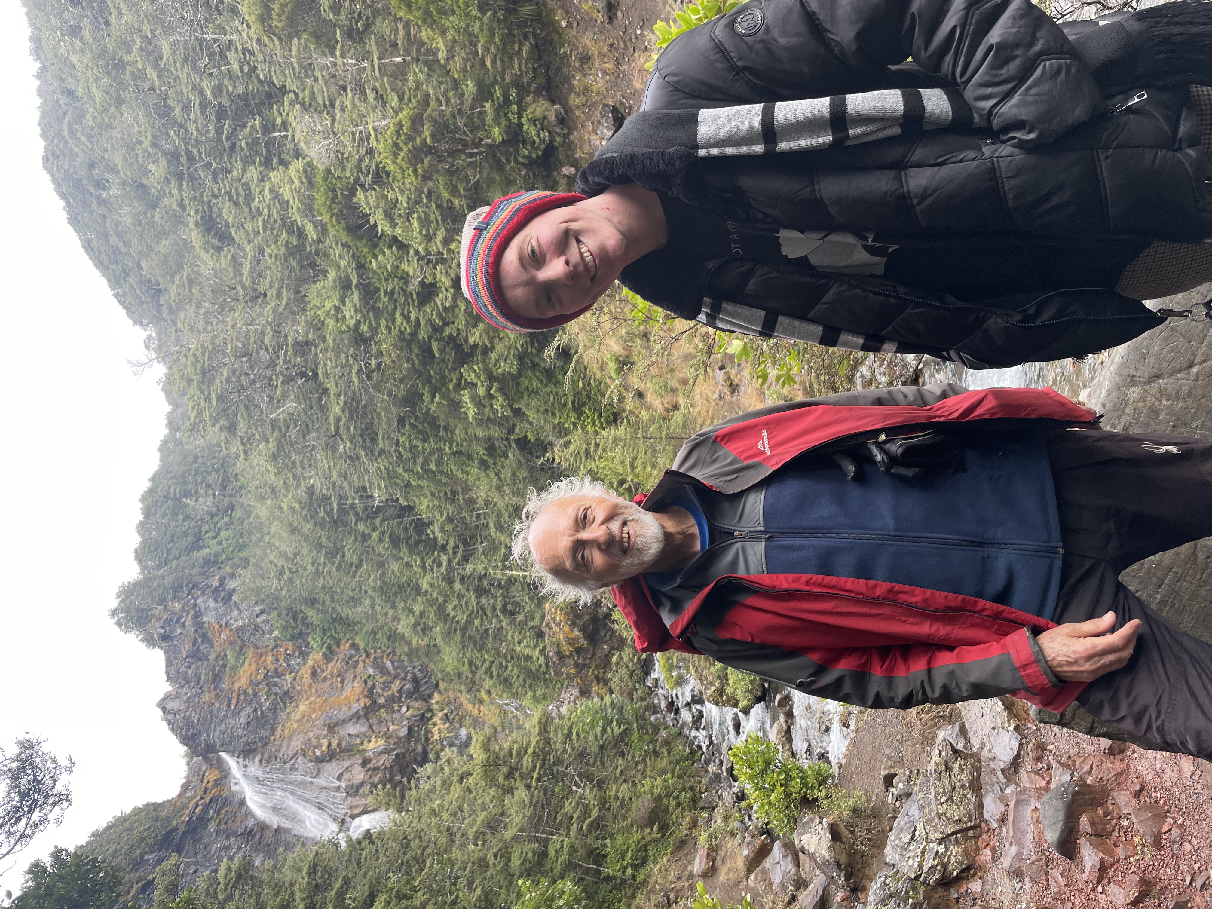 Lorne standing next to an older man in front of a large waterfall and river