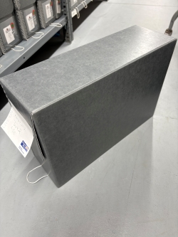 Black-and-white image of an oblong box sitting on tile floor