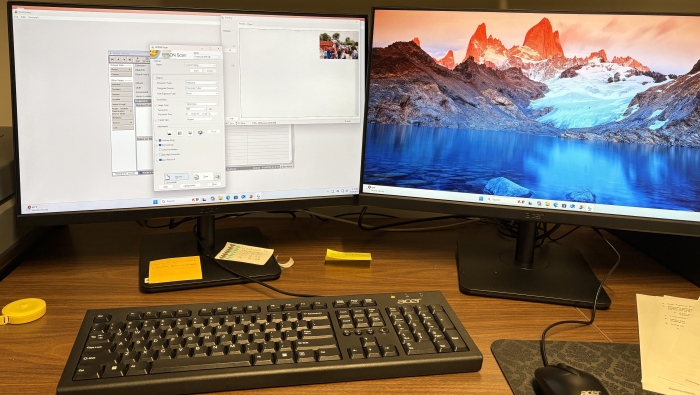 The intern computer desk setup for creating a finding map for the Wynn collection. There are two computer monitors, a keyboard, and mouse.
