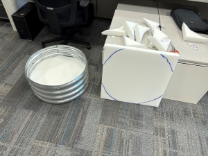 View of cut foam circles in a neat pile plus an uncut foam square with the places to cut marked