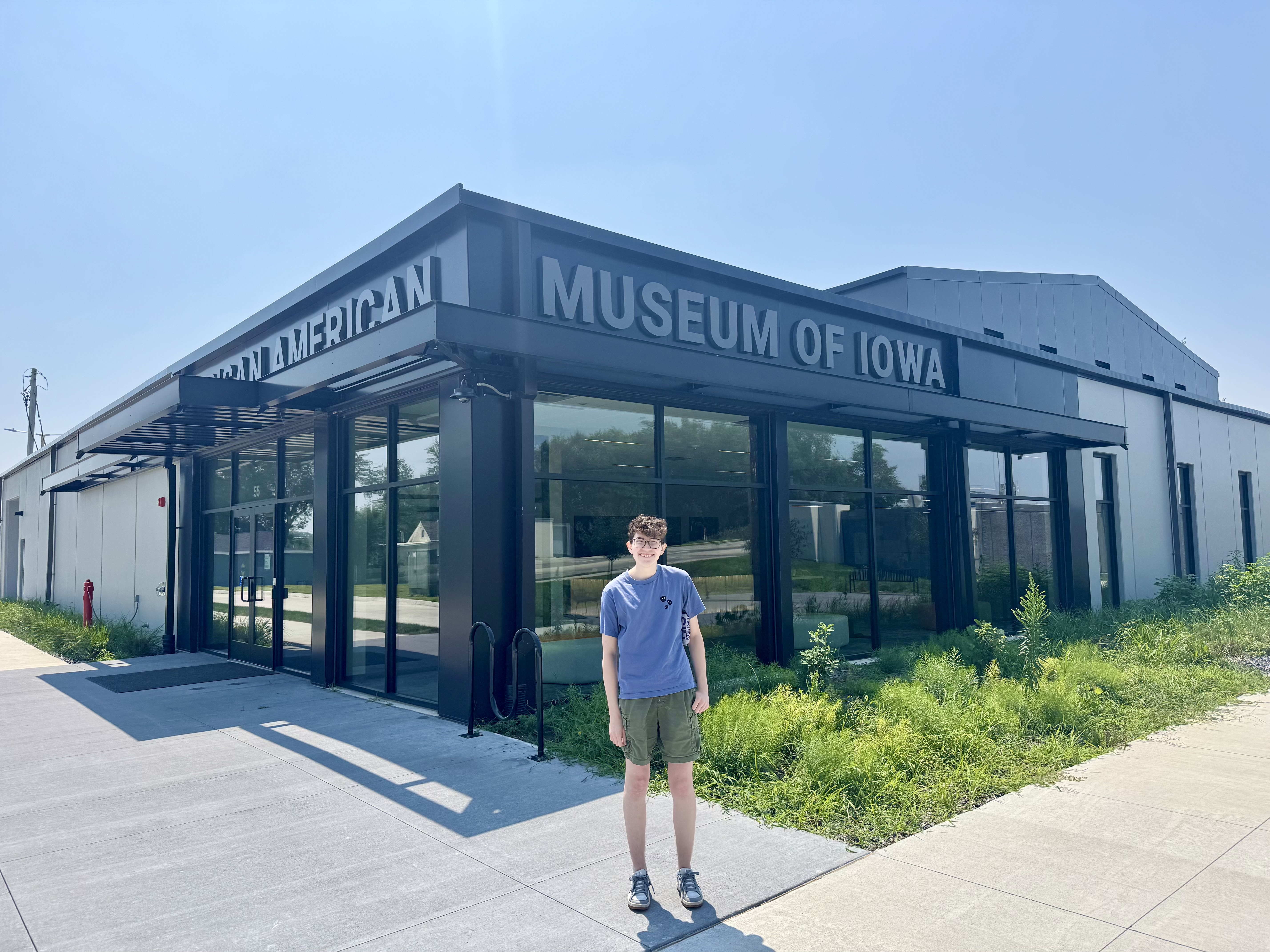 Orion poses outside the African American Museum of Iowa building