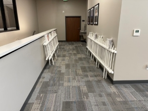 Assembled white picket fences lie propped against the walls in an office hallway