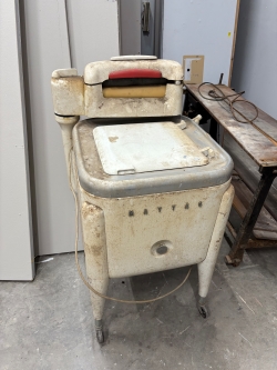An old dusty, dirty 1930s Maytag washing machine