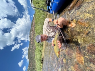 Luke, Sean's brother, holding a healthy rainbow trout on one of their float trips.