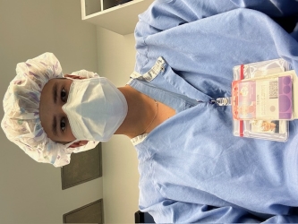 Selfie of Sean wearing scrubs, a medical mask, and a shower cap to conceal his hair
