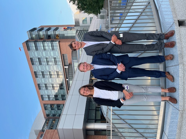 Sophie and Sean with their mentor Dr. Patrick Carry in the middle, all posing in front of Children's Hospital Colorado