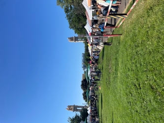 View walking into an outdoor farmer's market with tented vendors