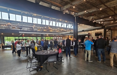 Large crowd of people mingling in an indoor bar/restaurant space