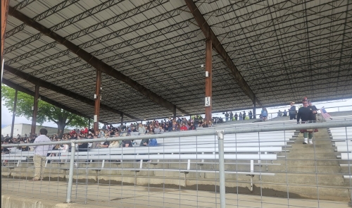 View of a section of outdoor bleachers mostly filled with people