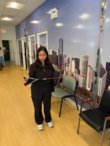 Image shows Andrea stretching an elastic band used for muscle training