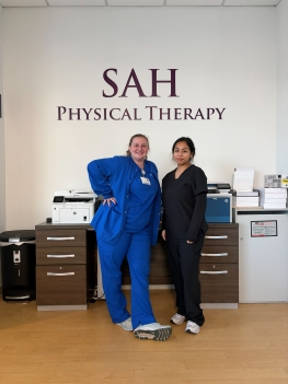 This image shows Andrea in front of an SAH Physical Therapy sign with PT Nicole Cook, a Cornell College Alumni. 