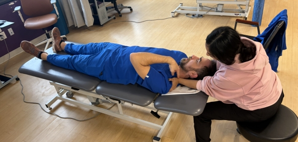 Andrea stretching a PT's neck muscles.
